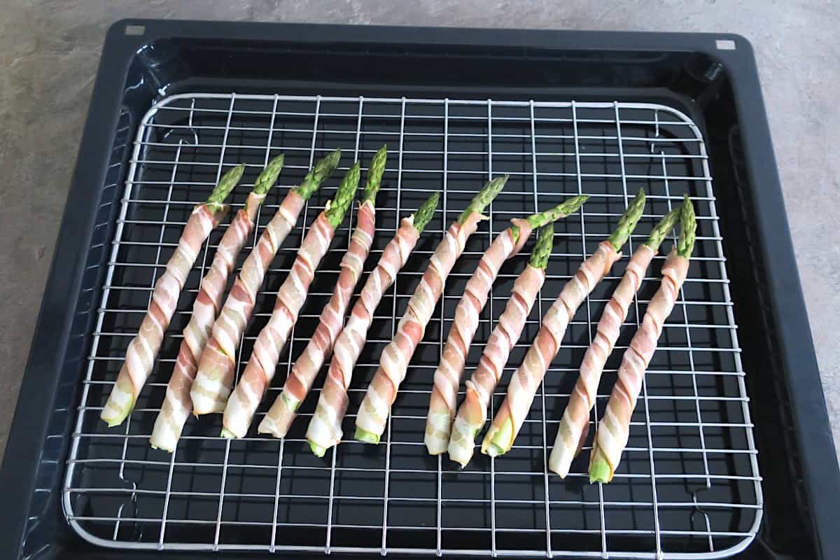 Bacon wrapped asparagus on an oven rack