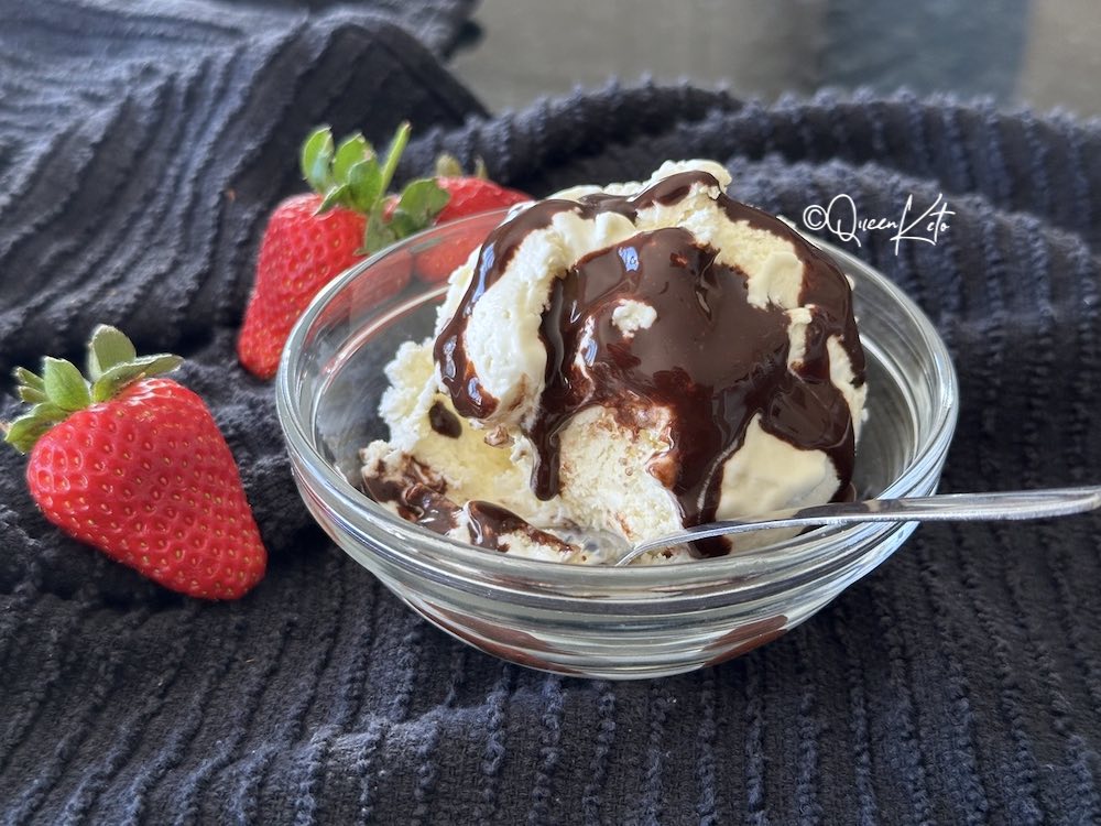 Keto ricotta ice cream with dark chocolate sauce and fresh strawberries in a glass bowl