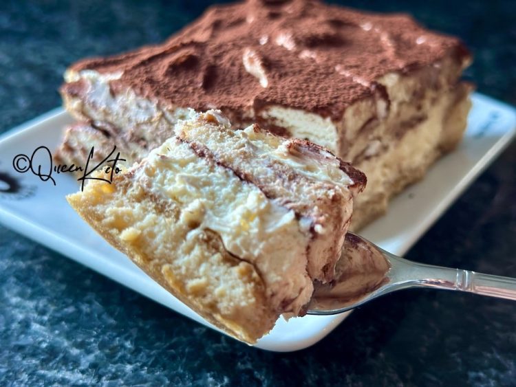 A slice of almost zero-carb carnivore tiramisù lifted from the dish on a cake server